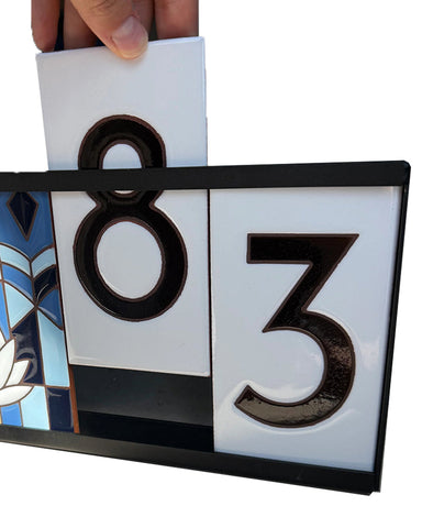Decorative house number sign with '83' on a white background