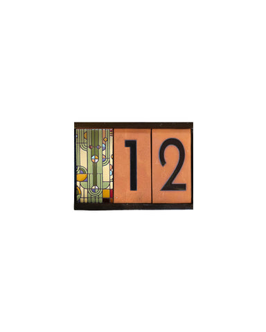 Decorative house number sign with stained glass design and numbers '12' on a white background