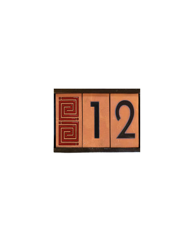 Decorative house number sign with the number 12 on a white background