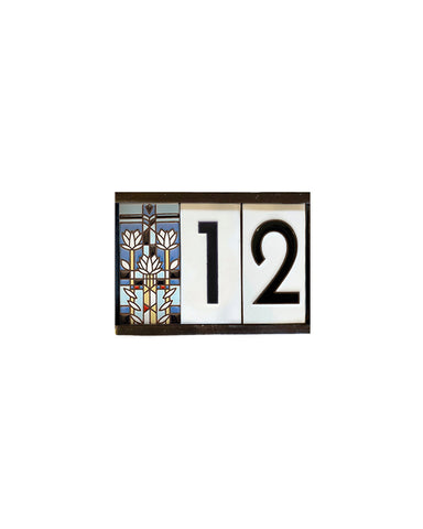 Decorative house number sign with stained glass design on a white background